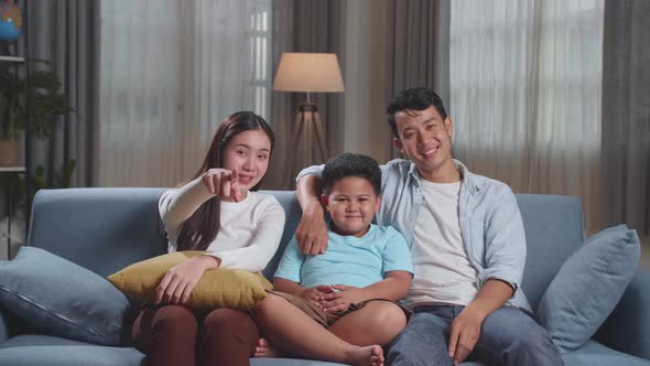 Asian Family, Leisure And People Concept - Happy Smiling Father, Mother And Son Watching Tv At Home