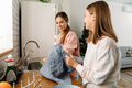 White mother and daughter smiling while washing dishes in kitchen - PhotoDune Item for Sale