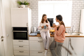 White mother and daughter talking and drinking tea in kitchen - PhotoDune Item for Sale