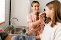 White mother and daughter making fun while washing dishes in kitchen - PhotoDune Item for Sale
