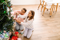 White mother and daughter decorating christmas tree together - PhotoDune Item for Sale