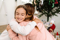 White mother and daughter hugging while decorating christmas tree - PhotoDune Item for Sale