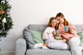 White mother and daughter drinking tea while resting on sofa - PhotoDune Item for Sale