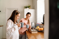 White mother and daughter talking and drinking tea in kitchen - PhotoDune Item for Sale
