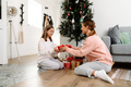 White mother and daughter smiling while giving presents to each other - PhotoDune Item for Sale
