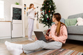 White mother and daughter using laptop and decorating christmas tree - PhotoDune Item for Sale