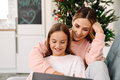 White mother and daughter using laptop together while sitting on sofa - PhotoDune Item for Sale