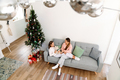 White mother and daughter smiling and talking while resting on sofa - PhotoDune Item for Sale