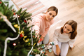White mother and daughter decorating christmas tree together - PhotoDune Item for Sale