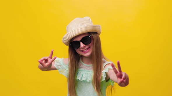 Cute Smiling Kid Girl Showing Thumbs Up Posing Isolated on Yellow Studio Background