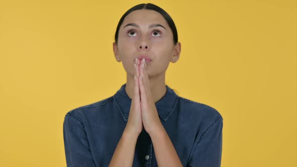 Latin Woman Praying Yellow Background