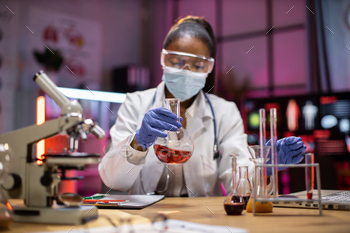 al service holding flask with lab glassware and test tubes in chemical laboratory background, science laboratory research and development medicines.