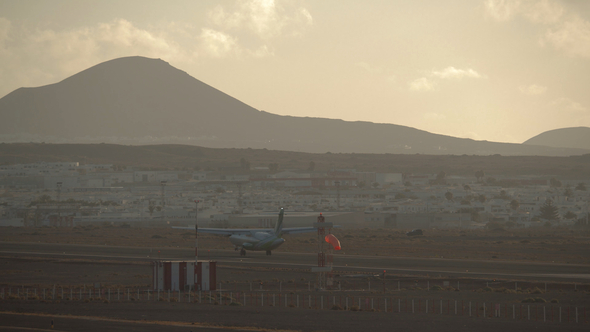 Airplane Landing in Scenic Town with Hills Landscape