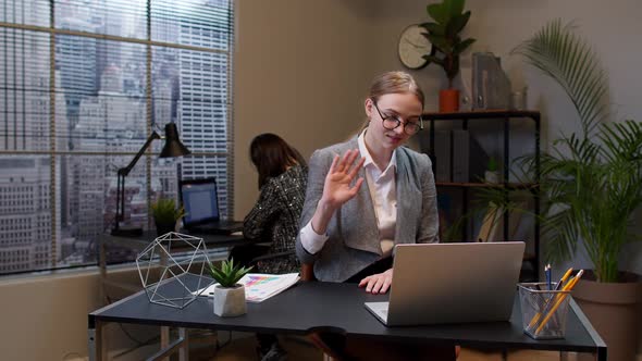 Focused Businesswoman Waving Hand Hi Hello Bye Talking Looking Into Laptop Computer at Home Office