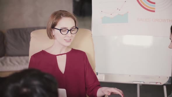 Successful Confident Caucasian Businesswoman in Glasses Speaking at Company Team Meeting in Modern