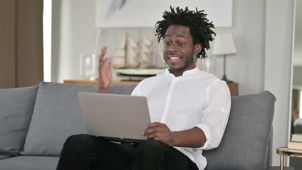 African Man Doing Video Chat on Laptop at Home 