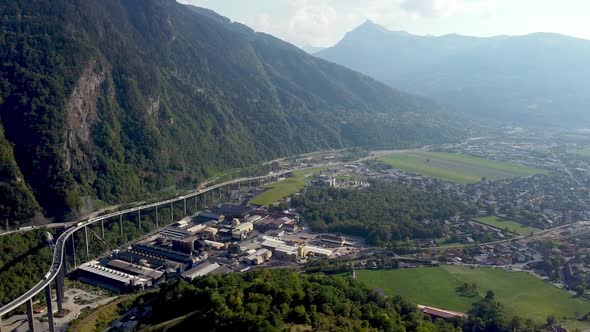 Aerial pan left from a polluted valley to a highway in the mountains. Vallée de l'Arve, French Alps.