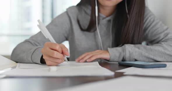 Woman write on the note paper ,study with cellphone