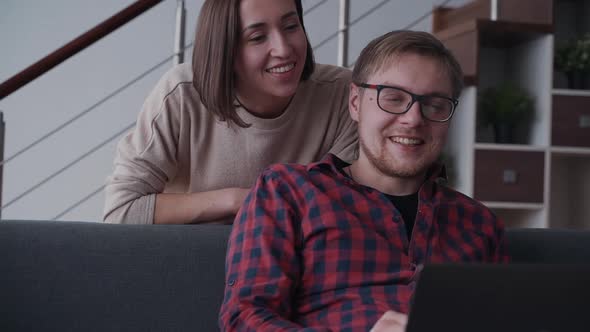 Man and Woman Using Laptop and Relaxing at Home