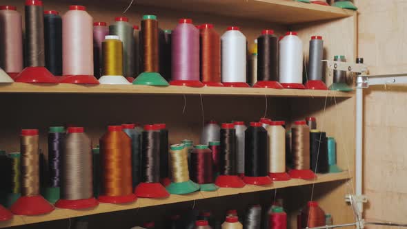 Assorted Colorful Spools of Thread on Shelves in Shoemaker Workshop Slow Motion