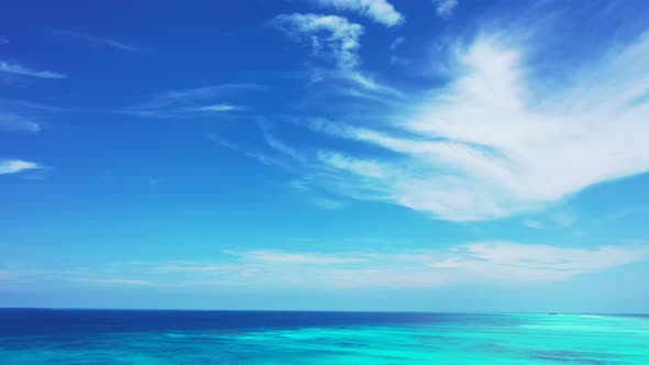 Daytime fly over abstract shot of a sunshine white sandy paradise beach and blue ocean background in