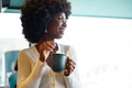 Young afro woman taking break and drinking coffee in cafe - PhotoDune Item for Sale