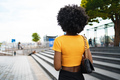 Smiling fashionable afro american woman walking on city street - PhotoDune Item for Sale