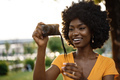 Smiling African american woman using professional camera at a street - PhotoDune Item for Sale