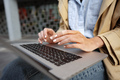 Close up of female hands typing on computer keyboard of a laptop sitting in the street - PhotoDune Item for Sale
