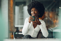 Young afro woman taking break and drinking coffee in cafe - PhotoDune Item for Sale