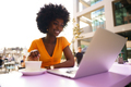 Happy beautiful young black woman using laptop in cafe - PhotoDune Item for Sale