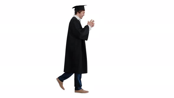 Happy Male Student in Graduation Robe Walking and Kissing His Diploma on White Background.