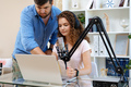 Female radio host recording podcast in studio, man colleague helps her to adjust sound. - PhotoDune Item for Sale