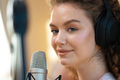 Portrait of happy young female radio host broadcasting in studio - PhotoDune Item for Sale