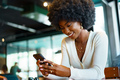 Young afro woman using mobile phone at coffee shop - PhotoDune Item for Sale