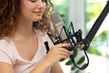 Portrait of happy young female radio host broadcasting in studio - PhotoDune Item for Sale