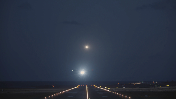 A Night View of a Runway with a Taking Off Plane