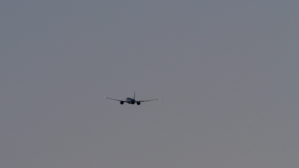 Plane Flying in Dull Grey Sky