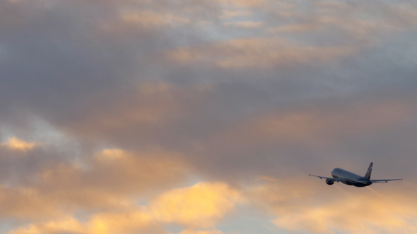 Airplane Flight in Cloudy Evening Sky