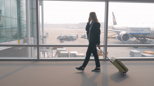 Woman Talking on Mobile in Airport Terminal