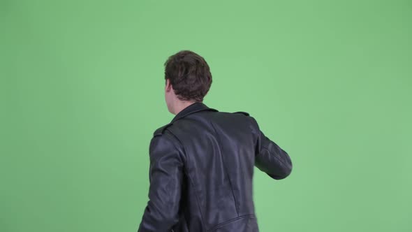 Rear View of Happy Young Rebellious Man with Fists Raised