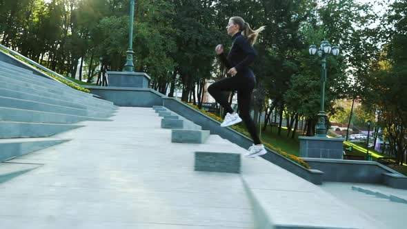 Woman jogging on staircase in city park