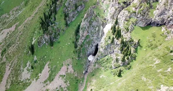 Top View of Steep Mountain Cliffs and an Ice Cave.