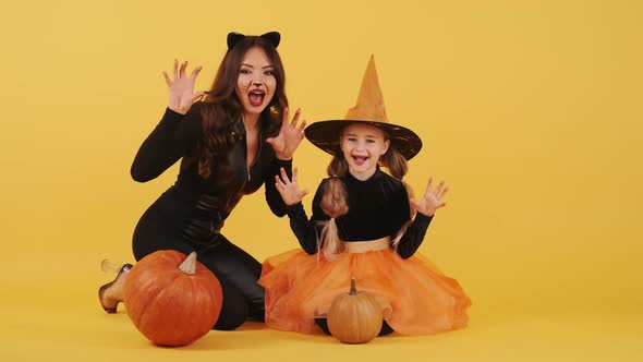 Mother and Daughter with Wearing Halloween Costumes Have in Orange Studio