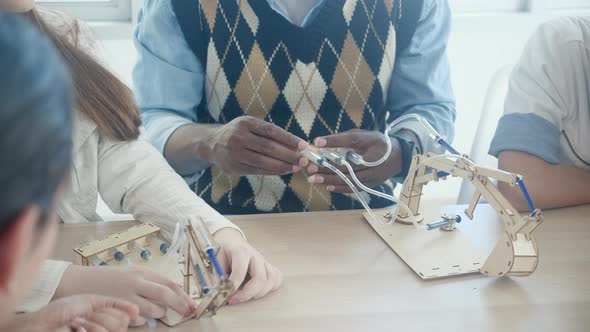 Young teacher teaching group student about science and explaining technology and creativity at lab.