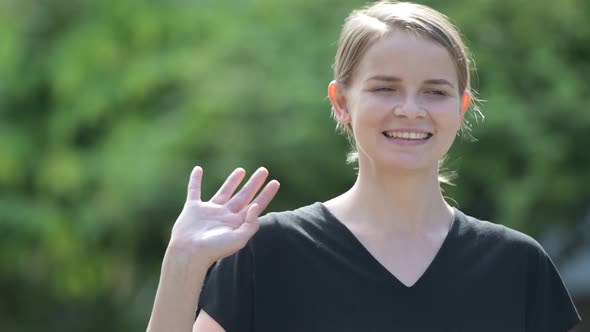 Young Happy Woman Thinking and Waving Hand Outdoors