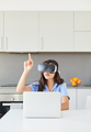Young woman with VR goggles clicking her finger in the metaverse world. - PhotoDune Item for Sale