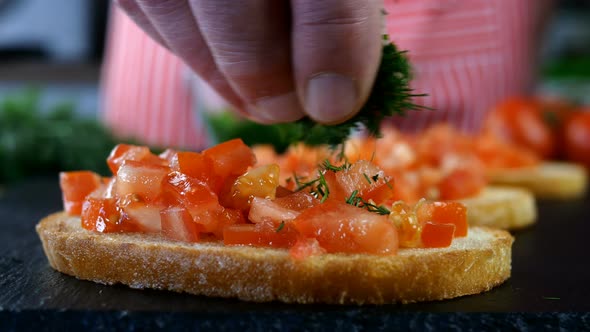 Chef Sprinkles Toasted Bread Finely Chopped Red Tomatoes with Dill to Make Sandwich or Bruschetta