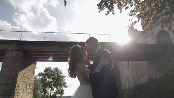 Groom with Bride Near Old Castle Bridge. Wedding Couple. Happy Newlyweds