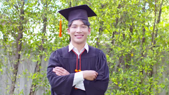 Asian Graduate man wear cap and gown so proud smile and happiness in Commencement day